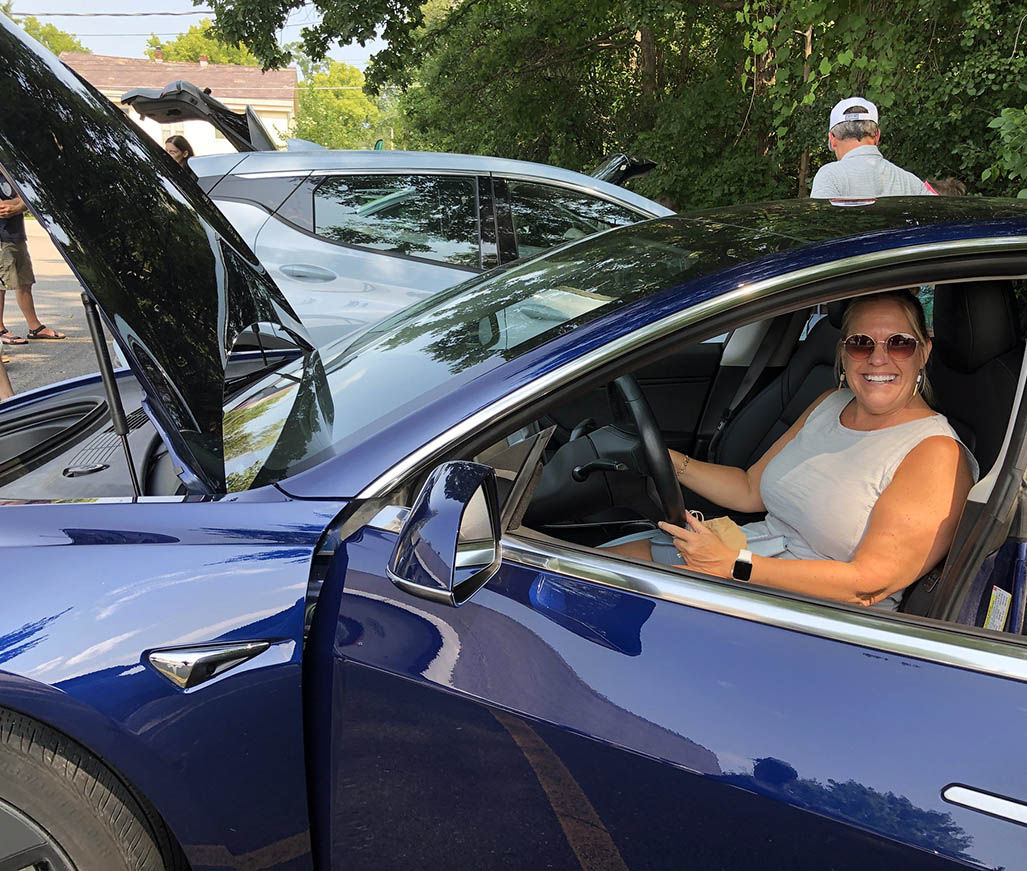 Woman sitting in a Tesla at a GMP EV event.