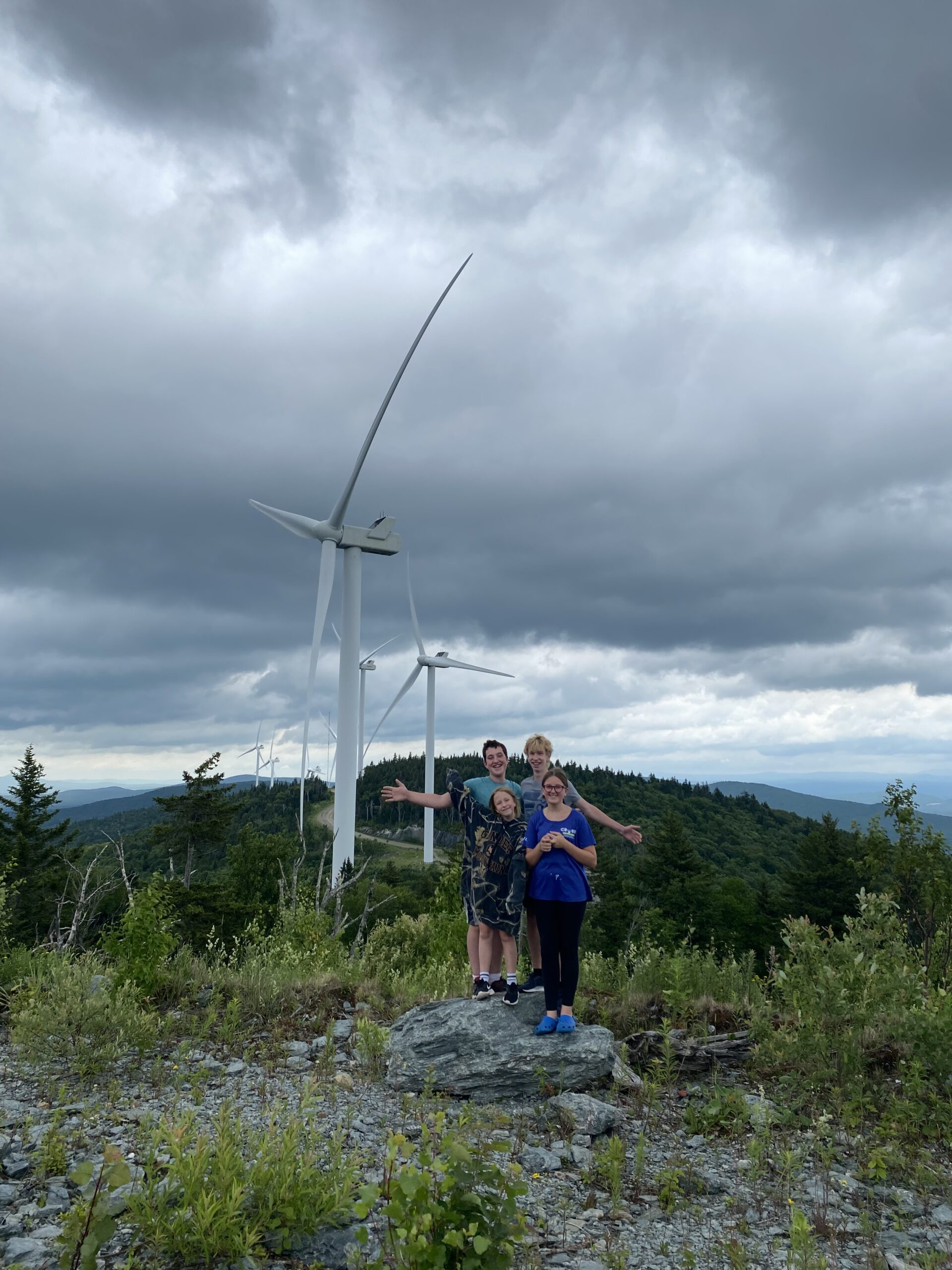 Smiling family in front of wind turbines